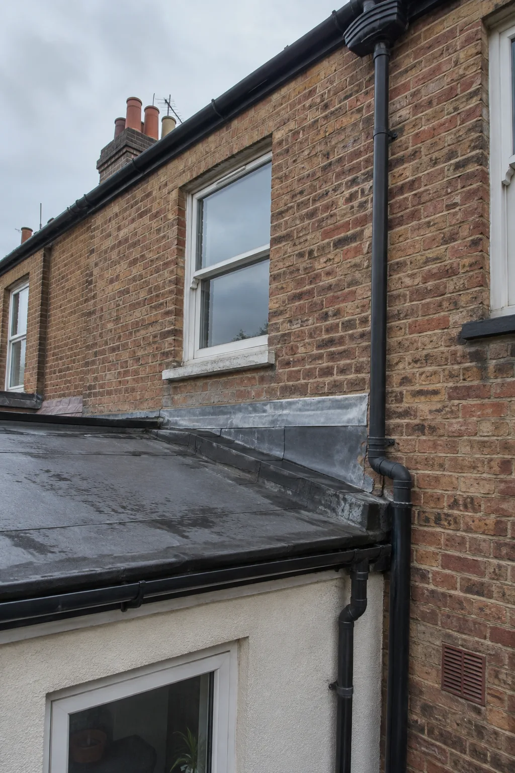 Rear brick wall and extension roof junction on a residential property